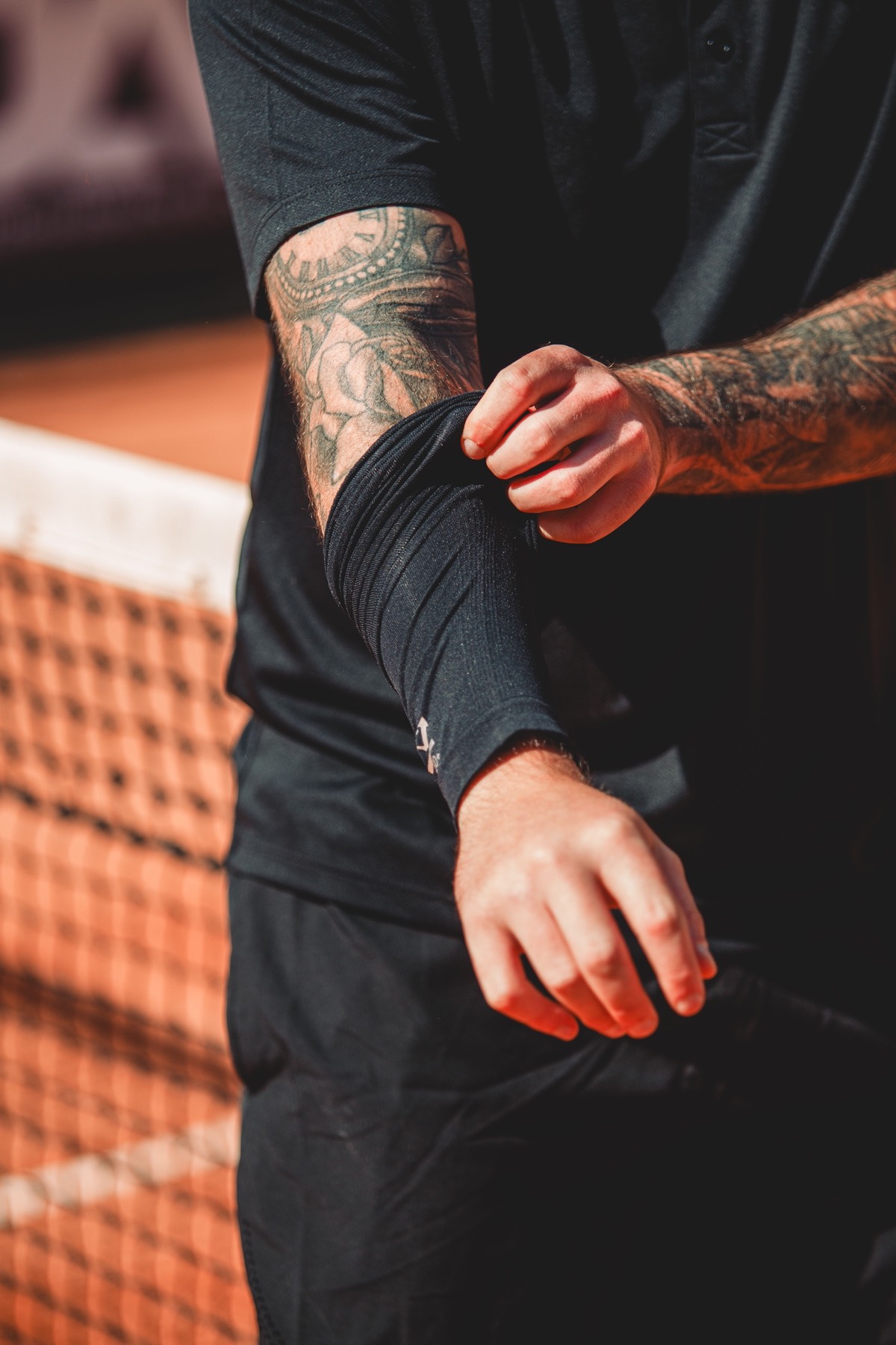Player pulling up the sleeve of a black compression top