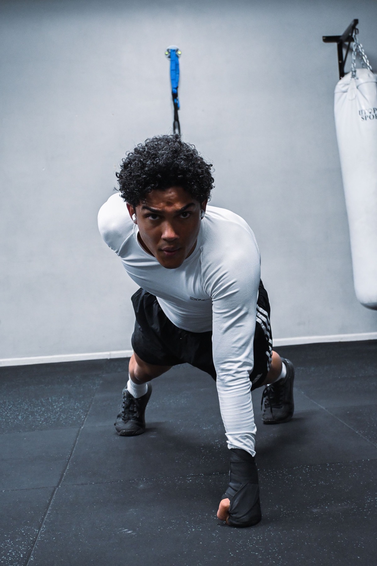 Athlete in a white long-sleeve top stretching in the gym